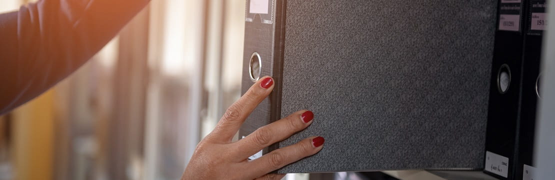 Woman places a folder on a shelf.